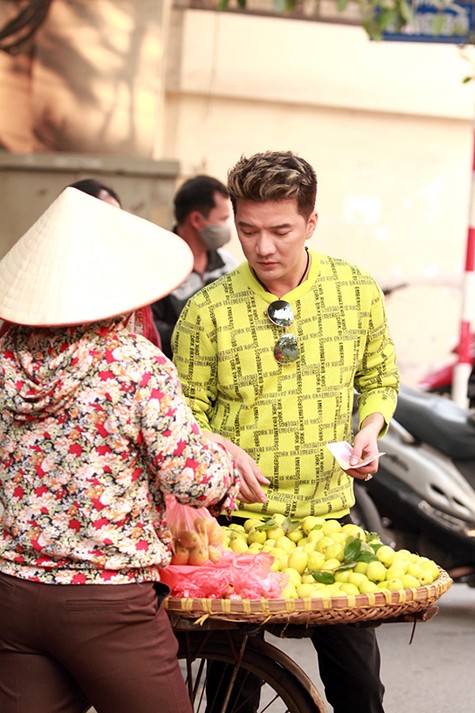 Mr Đàm mua đồ từ gánh hàng rong trên phố.